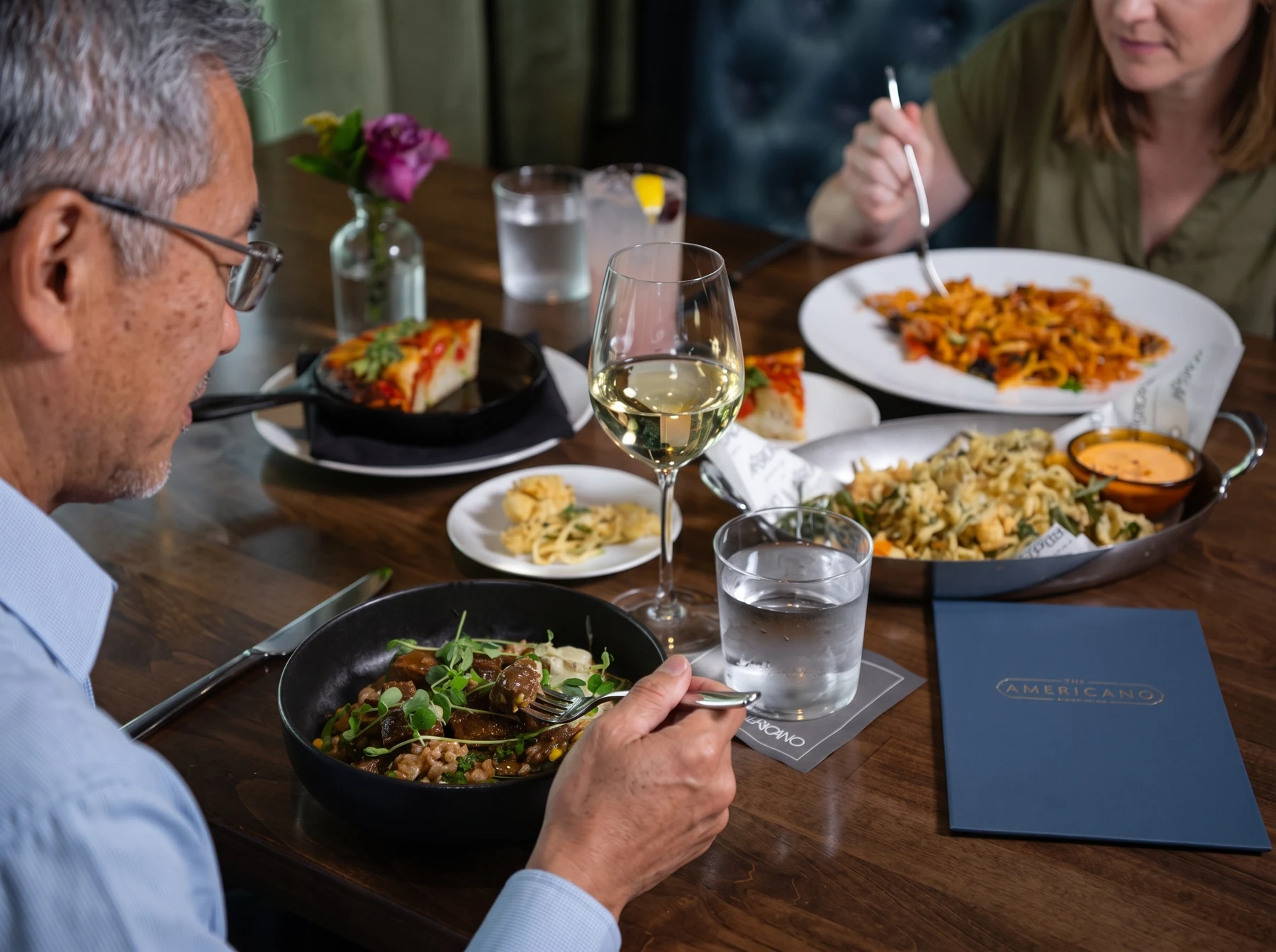 Diners enjoying pasta and wine at The Americano